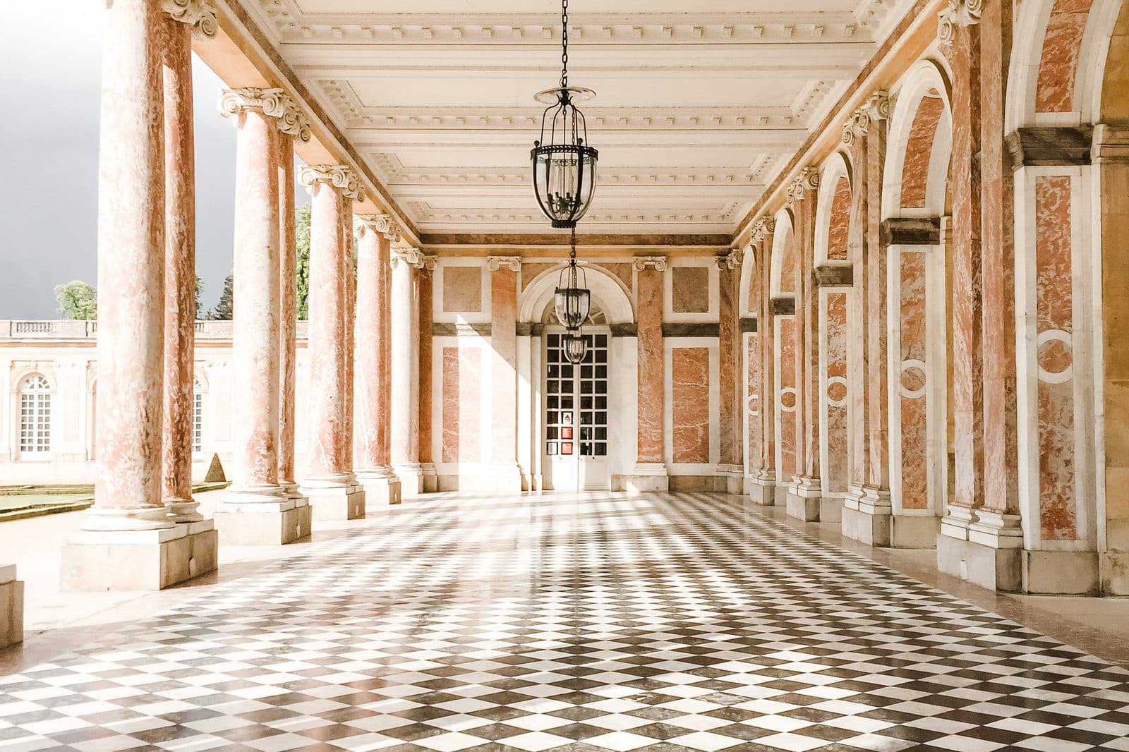 A grand marble colonnade wedding venue with a black-and-white checkerboard floor